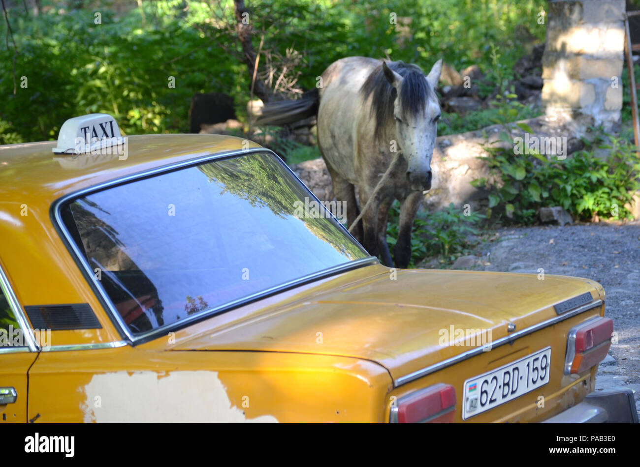 Taxi and horse in Ilisu village, north-western Azerbaijan Stock Photo