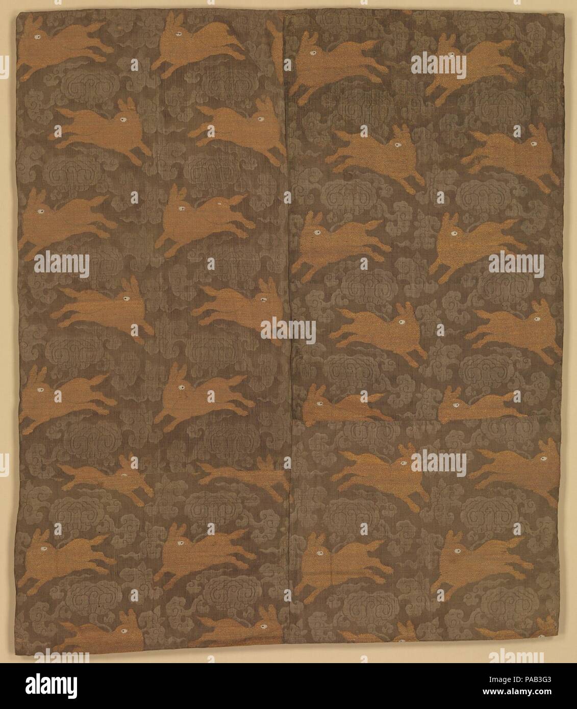 Panel with Rabbits amid Clouds. Culture: China. Dimensions: 40 1/2 x 33 1/2 in. (102.9 x 85.1 cm). Date: late 16th-early 17th century.  The rabbits running among clouds are intended to symbolize the moon, which is inhabited by rabbits in Chinese tradition. Richly brocaded with gold thread, this textile is both luxurious and auspicious. A similar length of gauze was found at Dangling, the mausoleum of the emperor Wanli (r. 1573-1620) in suburban Beijing, and it seems likely that this piece dates from the same period. Museum: Metropolitan Museum of Art, New York, USA. Stock Photo