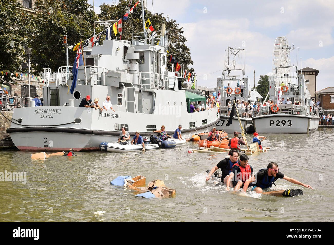 Teams paddle their slowly sinking cardbord boat in a race around Bristol's Floating Harbour