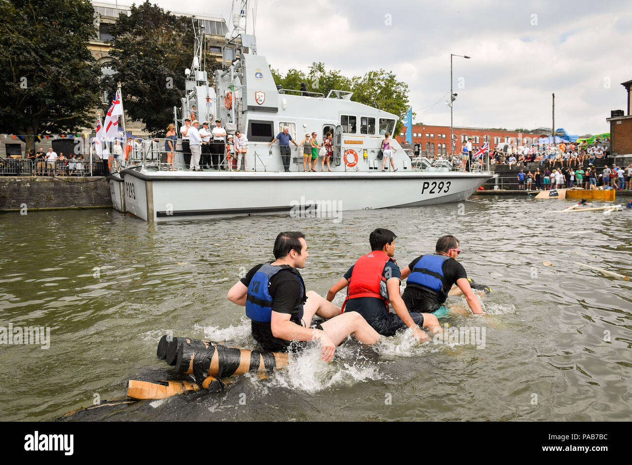 Teams paddle their slowly sinking cardbord boat in a race around Bristol's Floating Harbour, where only floating vessels made from cardboard are allowed, during the Harbour Festival in the city centre during hot sunny weather. Stock Photo
