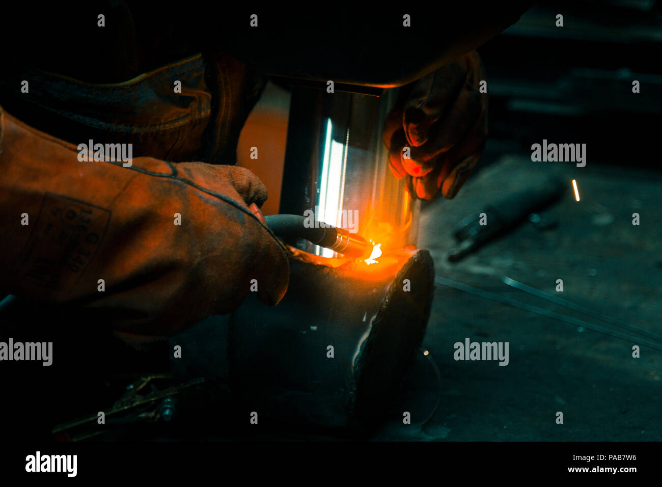 The welder lights the arc and begins to weld the metal structure of