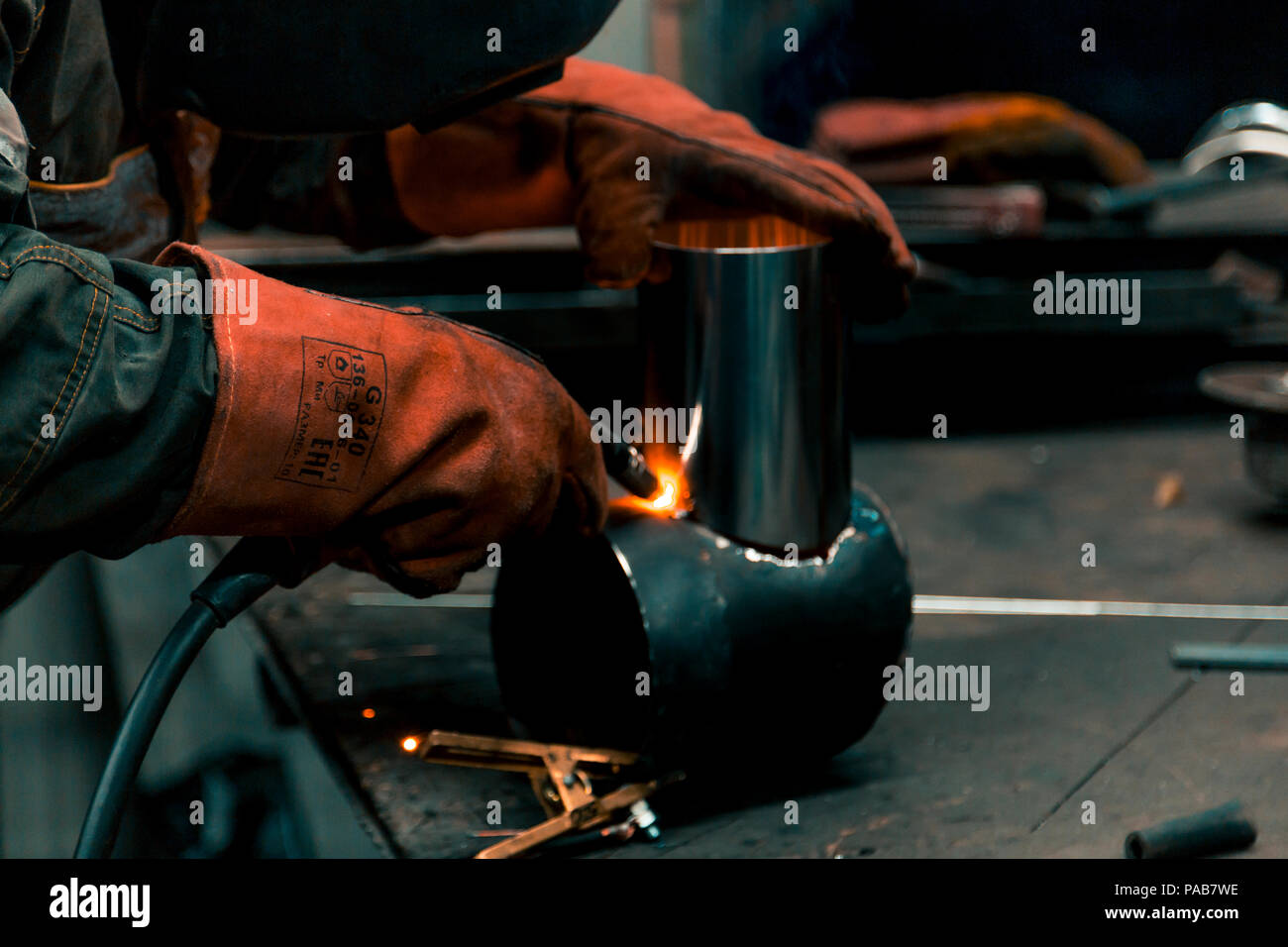 The welder lights the arc and begins to weld the metal structure of