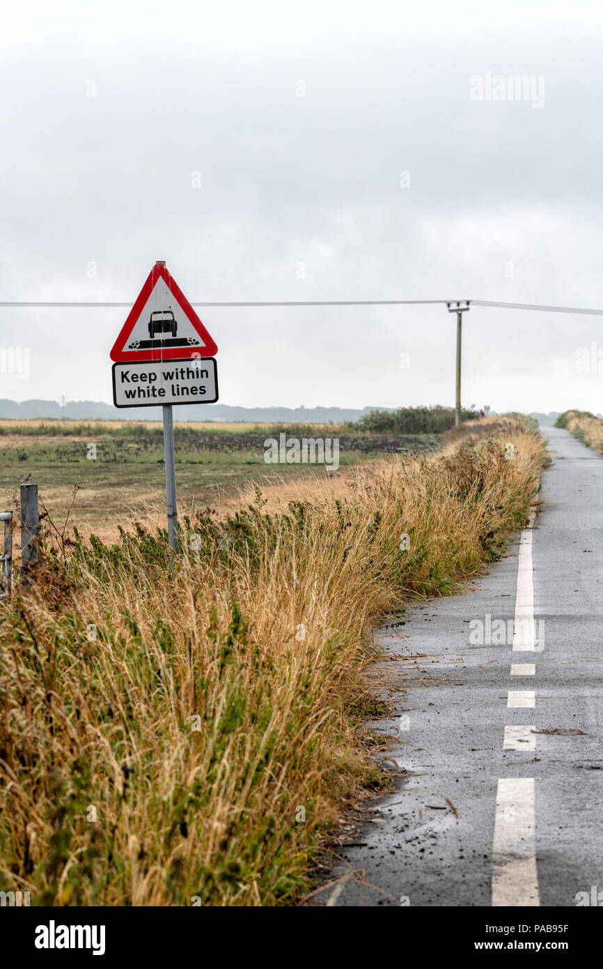 Road sign stating 'Keep Within White Lines' at the edge of a narrow country lane in Lytham, Lancashire, UK Stock Photo
