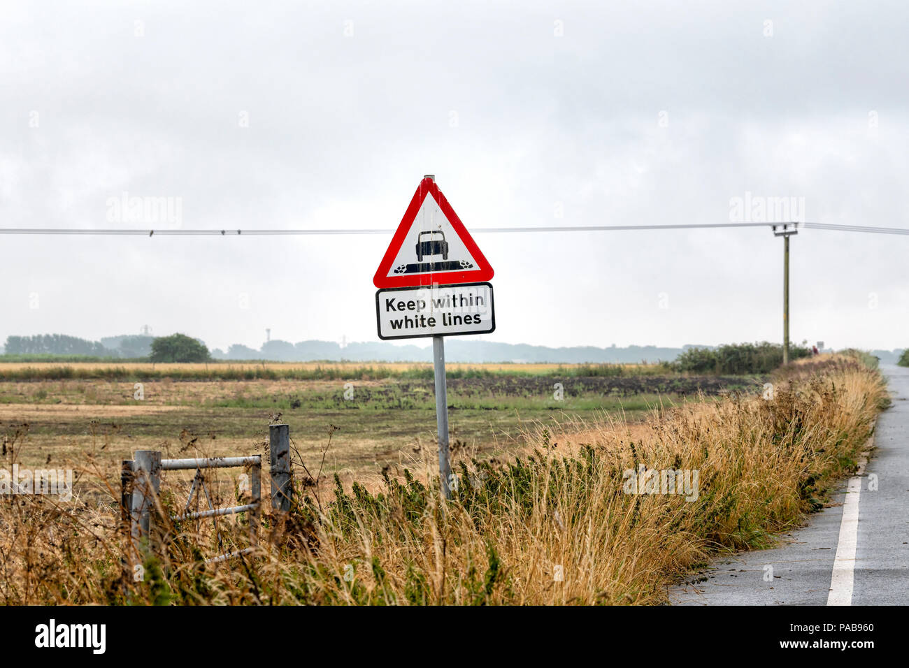 Road sign stating 'Keep Within White Lines' at the edge of a narrow country lane in Lytham, Lancashire, UK Stock Photo