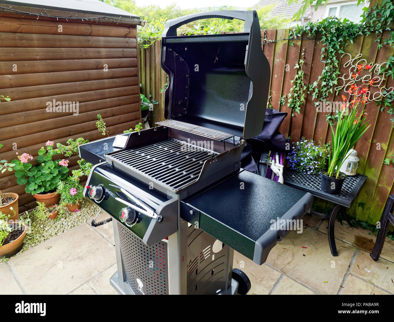 Gas BBQ in small garden. South Wales, UK. Stock Photo
