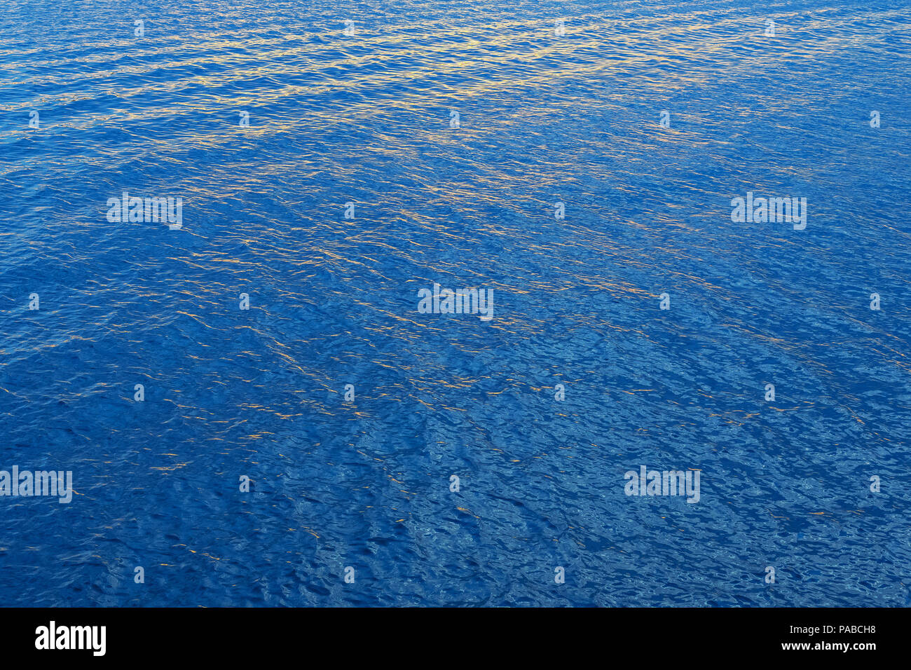 Calm water at sea with some small ripples and waves in clear blue ...