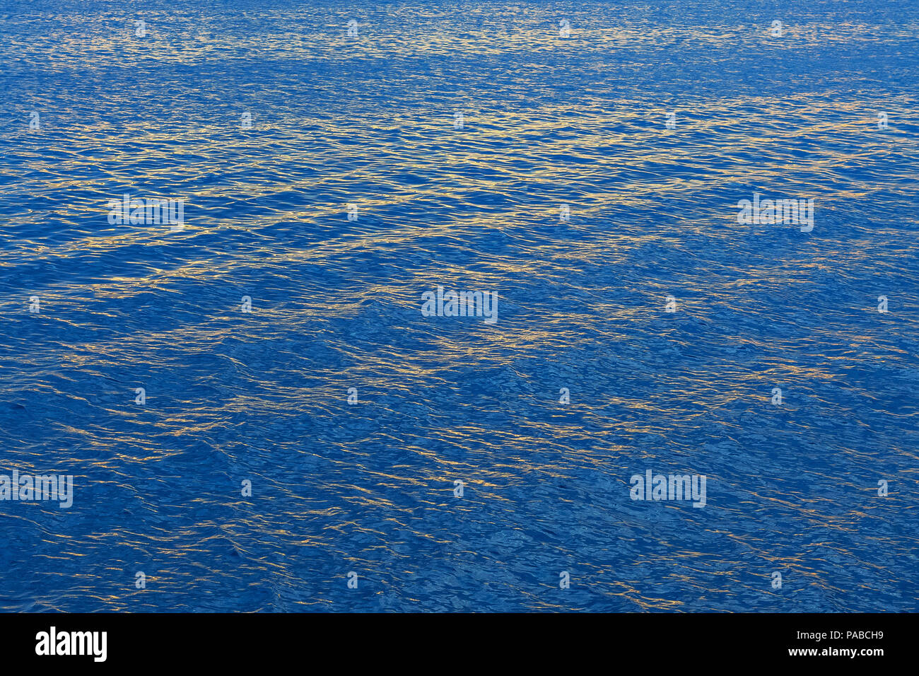 Calm water at sea with some small ripples and waves in clear blue ...