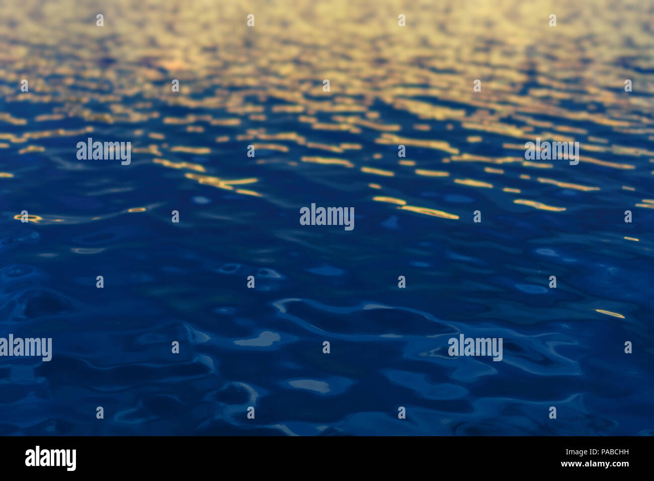 Calm water at sea with some small ripples and waves in clear blue ...