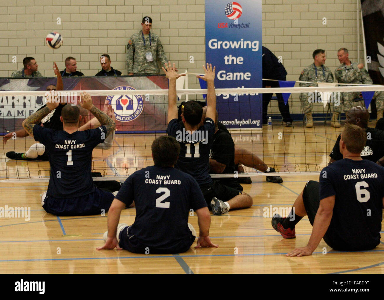 Team Navy/Coast Guard members strategically position themselves in a game of seated volleyball  against Team Army during the 2013 Warrior Games May 14. The Warrior Games includes competitions in archery, cycling, seated volleyball, shooting, swimming, track and field, and wheelchair basketball. The goal of the Warrior Games is not necessarily to identify the most skilled athletes, but rather to demonstrate the incredible potential of wounded warriors through competitive sports. More than 200 wounded, ill, or injured service members from the U.S. and U.K. armed forces are scheduled to compete i Stock Photo