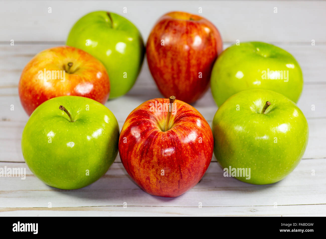 Green and red apples waiting to be eaten on the kitchen table Stock Photo