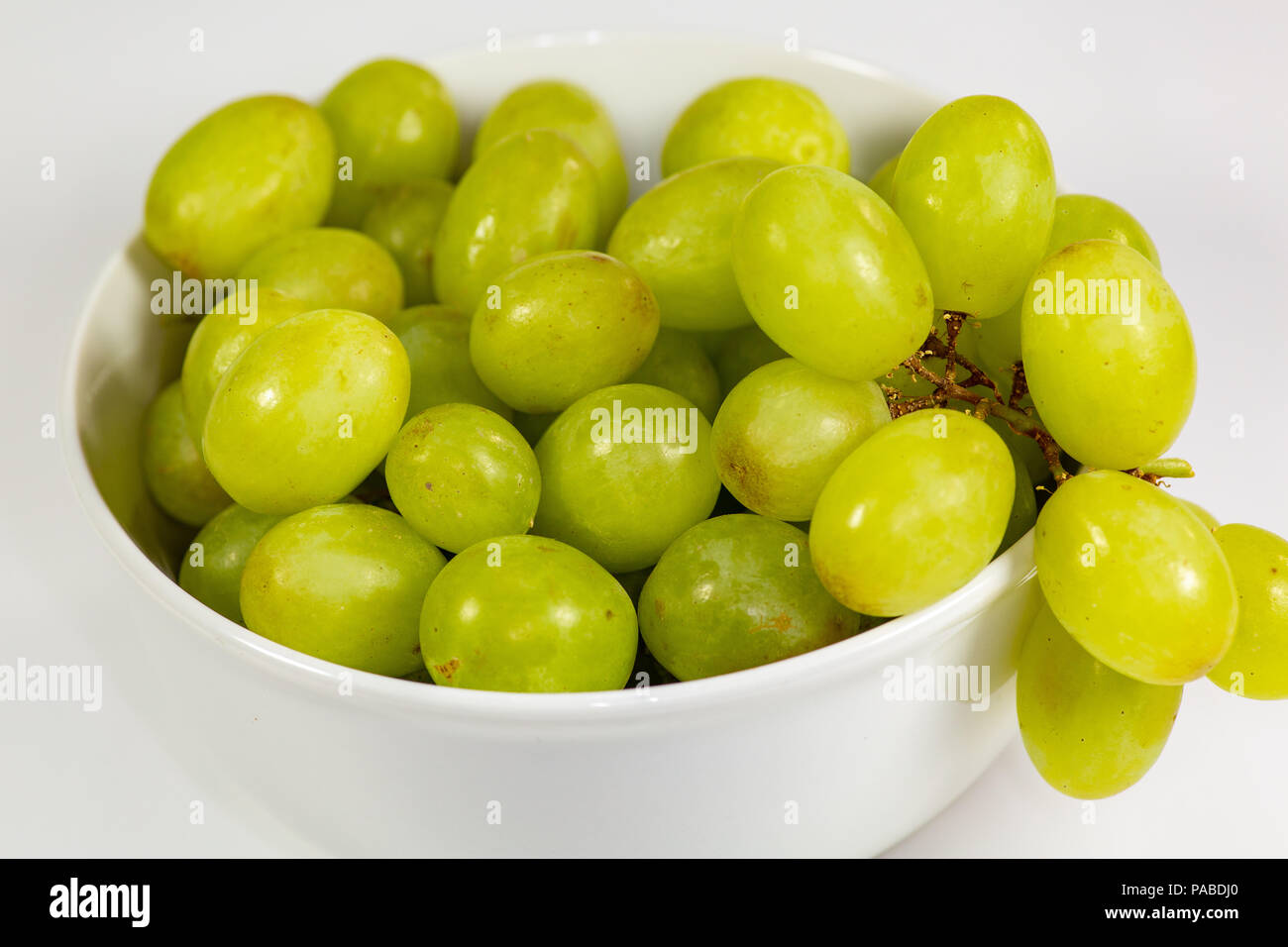 https://c8.alamy.com/comp/PABDJ0/green-seedless-grapes-in-a-deep-white-bowl-on-a-white-tale-waiting-to-be-eaten-PABDJ0.jpg