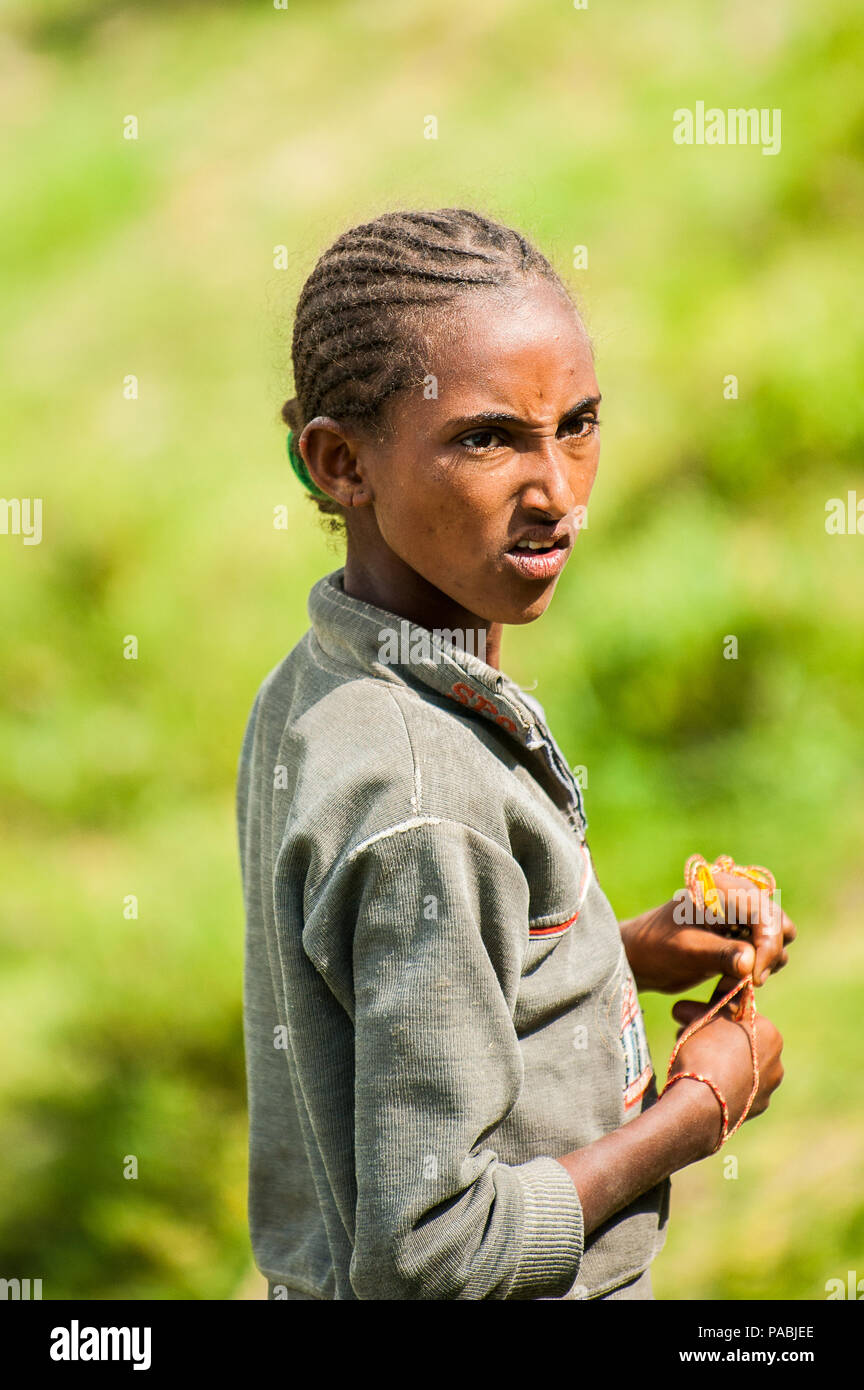 AKSUM, ETHIOPIA - SEPTEMBER 24, 2011: Unidentified Ethiopian angry irl with bracelets on her hand. People in Ethiopia suffer of poverty due to the uns Stock Photo
