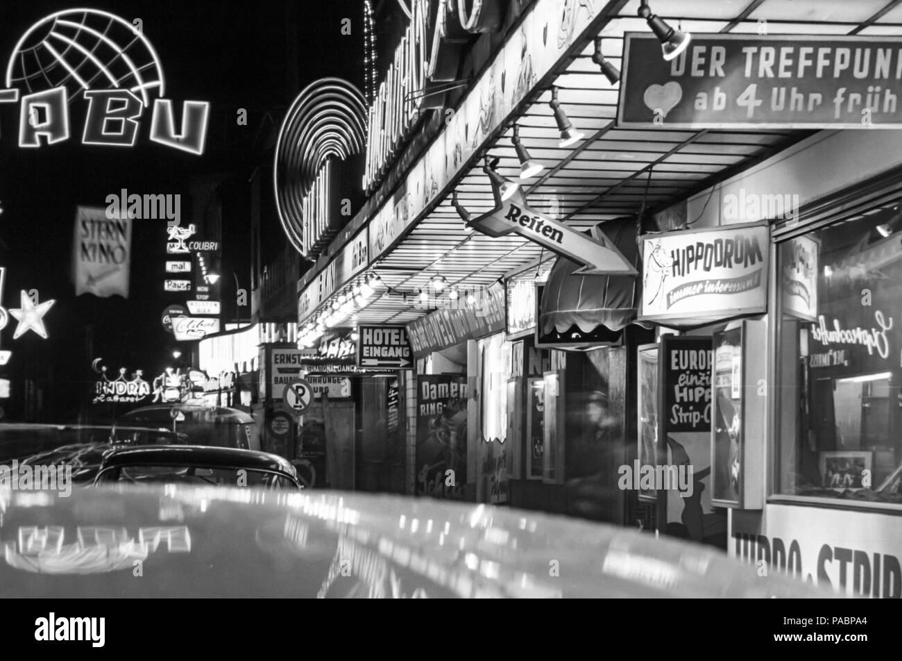 Black and white photo of the neon lights of the nightclubs in Grosse Freiheitstrasse, at night off the Reeperbahn, Hamburg, Germany in the 1960s Stock Photo