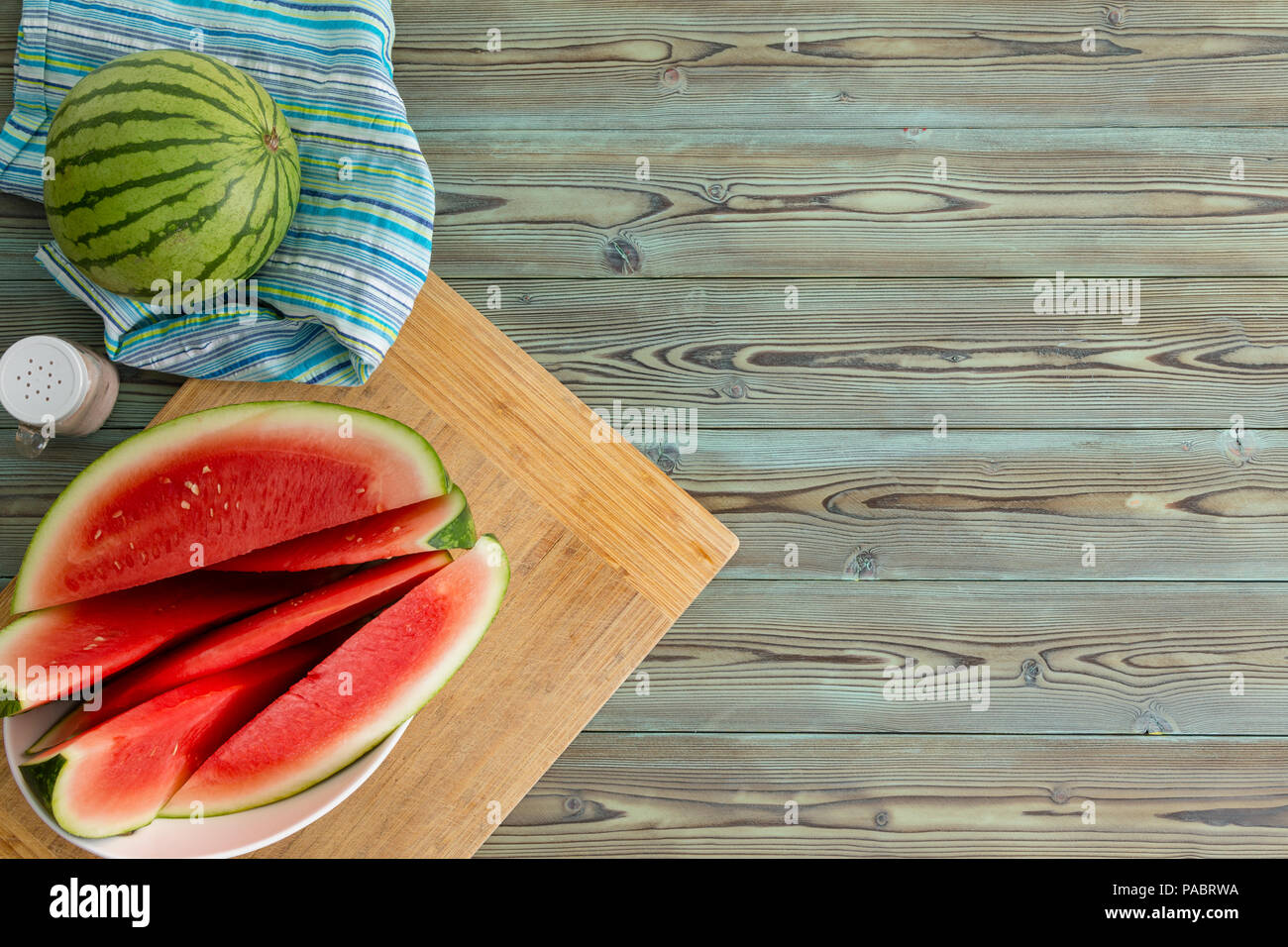 Refreshing juicy sliced fresh watermelon on a plate on a cutting board served on a wooden picnic table for a summer dessert with copy space from above Stock Photo