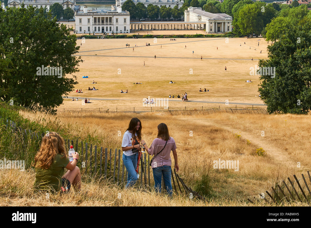 Tourists and visitors on the hill at Greenwich Park, South East London UK,  during the 2018 heatwave, with the Royal Naval College buildings Stock Photo