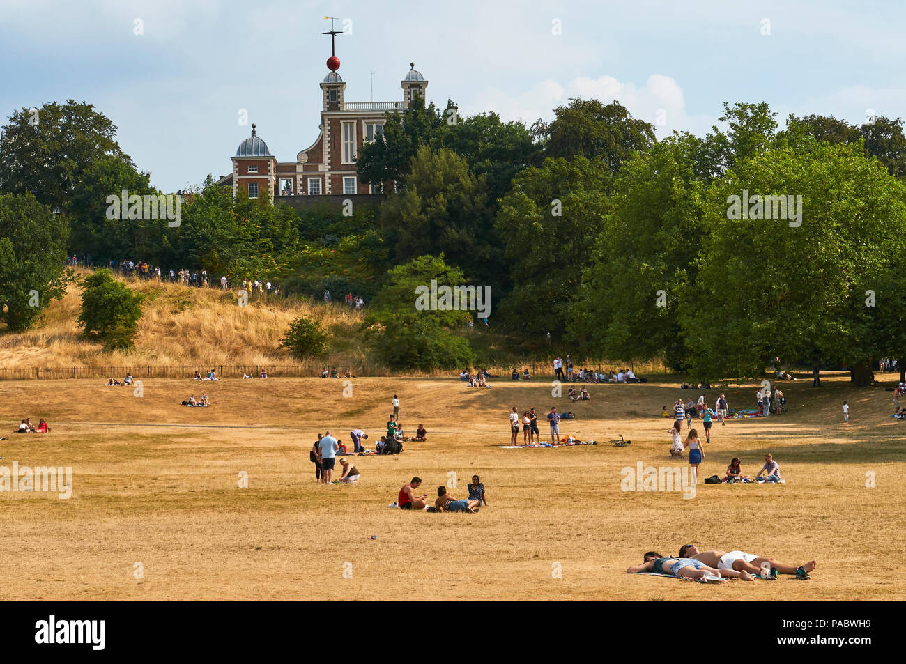 Sunbathers in Greenwich Park London during the 2018 heatwave, with Falmsteed House, Greenwich Royal Observatory, in the background Stock Photo