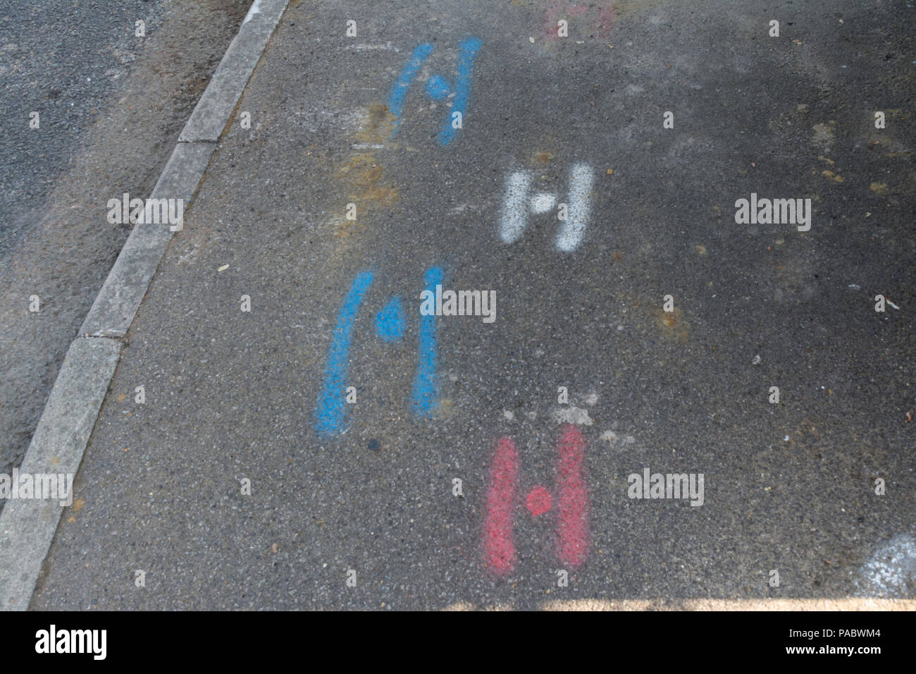 Spray painted markings squiggles on pavement made by contractors to