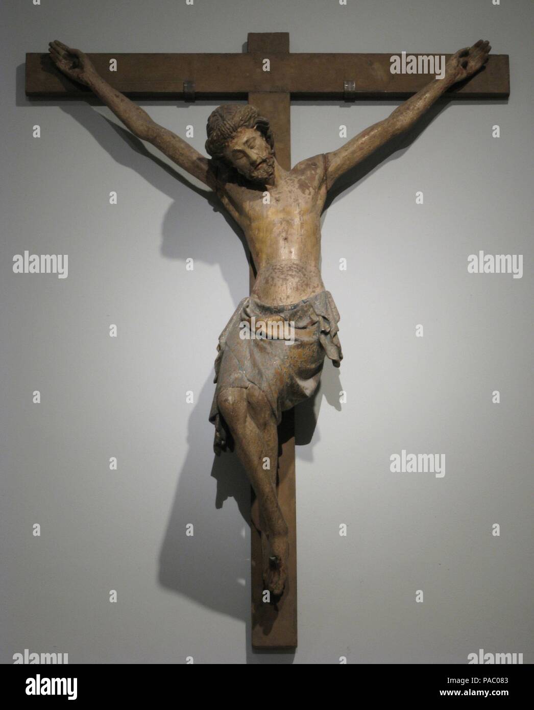 Crucifix. Culture: French. Dimensions: Overall (with cross): 59 3/4 x 45 5/8 x 13 1/8 in. (151.8 x 115.9 x 33.3 cm)  Overall (without cross): 55 1/8 x 41 5/16 x 12 1/8 in. (140 x 105 x 30.8 cm)  weight: 33lb. (15kg). Date: ca. 1300.  The image of the suffering Christ crucified with three nails emerged in western Europe in the 1100s. Such crucifixes, with Christ wearing a crown of thorns, played a part in devotions relating to the Passion liturgy. Museum: Metropolitan Museum of Art, New York, USA. Stock Photo