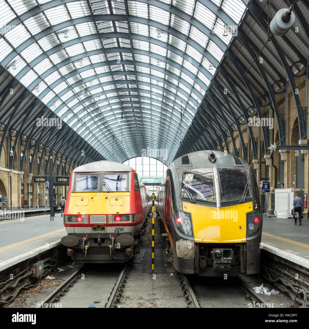 Platforms and trains at King's Cross railway station with Arriva's Grand Central Adelantes HST and The Yorkshire Artist, Ashley Jackson, on the right Stock Photo