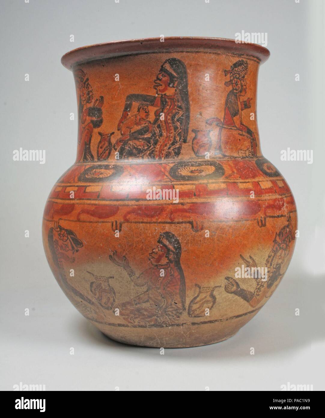Jar, Ritual Scenes. Culture: Maya. Dimensions: H. 11 1/2 in. x Diam. 12 in. (29.2 x 30.5 cm). Date: 8th-9th century.  The Classic Maya depicted many scenes of ritual imbibing of alcohol through enemas, and on this jar, several such scenes unfold around an upper and lower register. In paired-figure scenes, three around the neck and four around the body of the jar, a woman is shown taking care of a child, preparing a mixture in an enema bladder or gourd, and helping a male administer an enema to himself. The characters are painted in red, orange, and black, on a light orange background. The outf Stock Photo