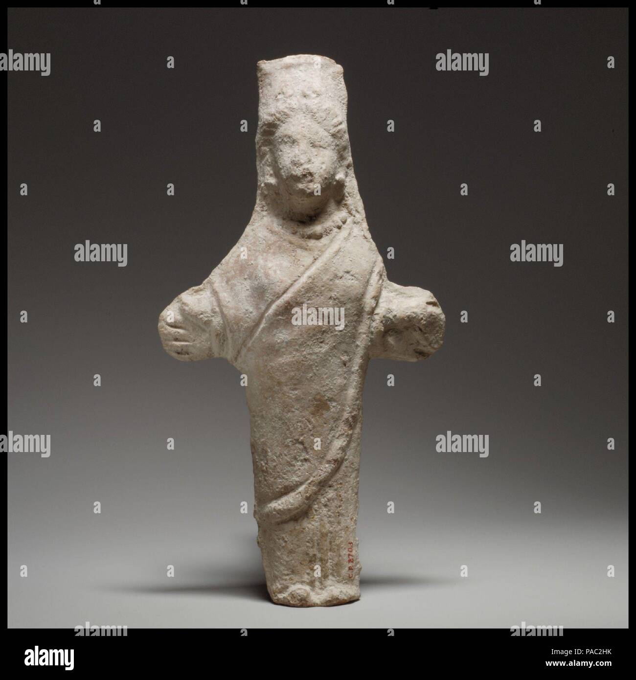 Standing female figurine (cruciform). Culture: Cypriot. Dimensions: H. 9 1/8 in. (23.2 cm). Date: 4th century B.C.(?).  The solid head and body are mold-made, the arms handmade. The back is handmade, flat, and pared. The crude, cruciform figure is in a frontal pose, the feet close together. Museum: Metropolitan Museum of Art, New York, USA. Stock Photo