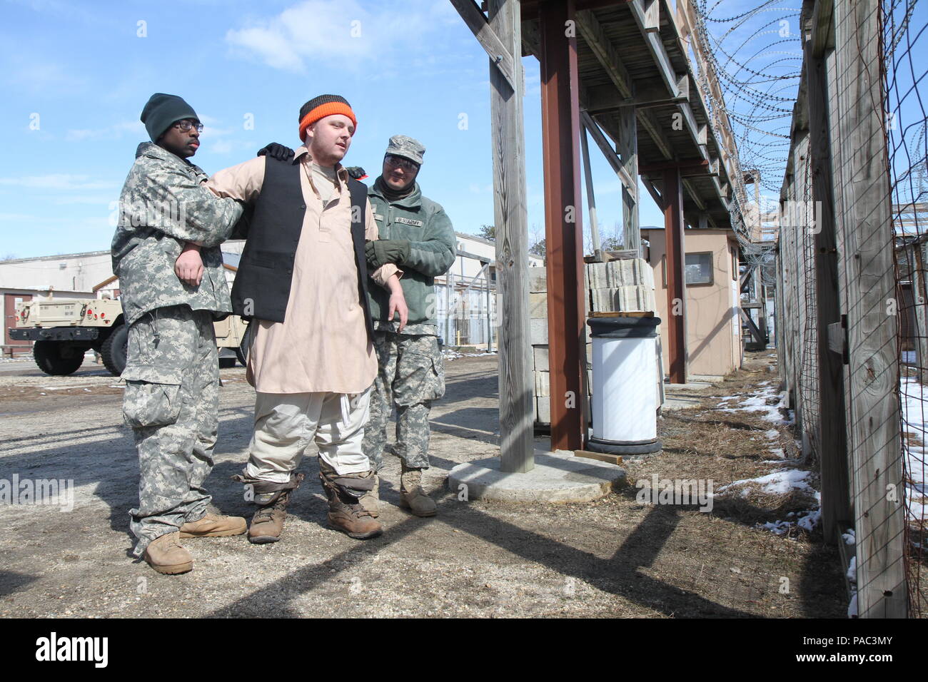 U.S. Army Soldiers of the 96th Military Police Battalion escort Pvt. Nick Tano of the 342nd Military Police Company (MP Company) to a simulated detention center on Joint Base McGuire-Dix-Lakehurst, N.J., March 5, 2016. Tano along with Soldiers of the 342nd MP Company acted as notional detainees to improve unit training during Combat Support Training Exercise 78-16-01. Stock Photo