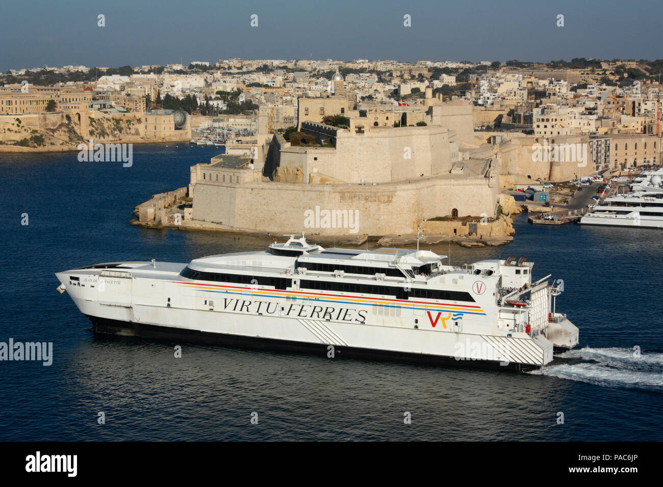 The catamaran Jean de la Valette departing from Malta en route to Sicily, with Fort St Angelo in the background. Transport by sea in the EU. Stock Photo