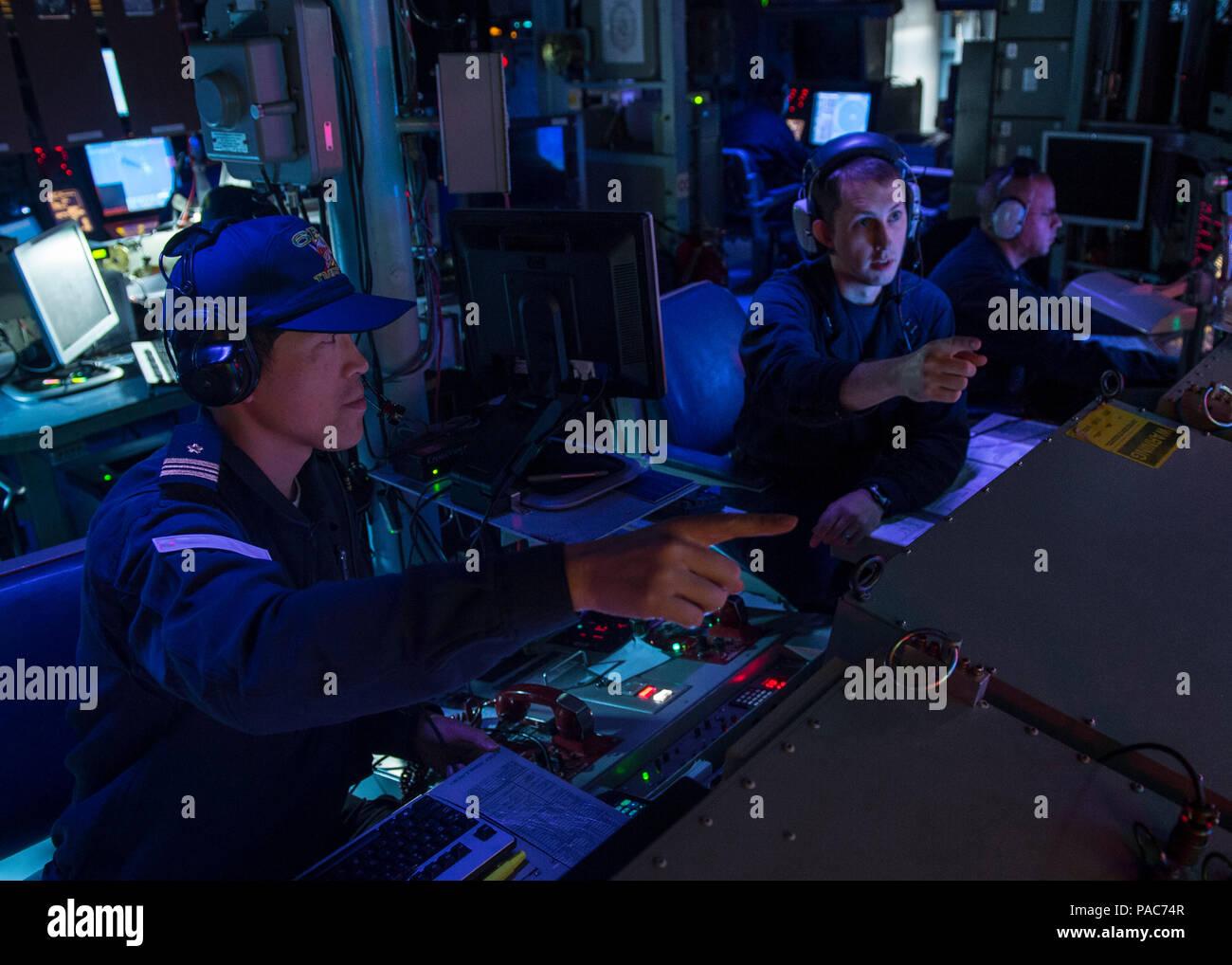 WATERS NEAR GUAM (Mar. 9, 2016) Lt. Thomas Brewer, (right), Chief Engineer of Arliegh Burke-class guided-missile destroyer USS McCampbell (DDG 85), and Japan Maritime Self-Defense Force (JMSDF) Lt. Cmdr. Hironori Ikeda, of JMSDF Chief staff, Escort Division 6, discuss tactical data from the Combat Information Center (CIC) during Multi Sail 2016. Multi Sail is a bilateral training exercise aimed at interoperability between the U.S. and Japanese forces. This exercise builds interoperability and benefits from realistic, shared training, enhancing our ability to work together to confront any conti Stock Photo