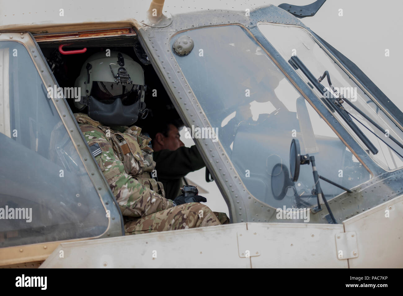 An Afghan Air Force pilot powers down an Mi-17 helicopter as a Train Advise Assist Command-Air Mi-17 Air Advisor looks out a cockpit window after a training mission at Kandahar Airfield, Afghanistan, March 3, 2016. Members of the 441st Air Expeditionary Advisory Squadron at KAF worked with AAF pilots on take-off, landing and emergency procedures. (U.S. Air Force Photo/Tech. Sgt. Robert Cloys) Stock Photo