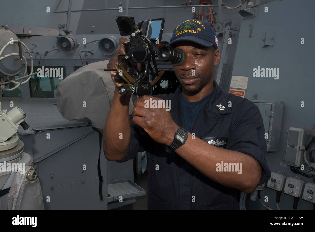 160309-N-MD297-023 PACIFIC OCEAN (March 9, 2016) - Quartermaster 1st Class John Lenson, assigned to the Arleigh Burke-class guided-missile destroyer USS Lassen (DDG 82), peers through a marine sextant, a navigational instrument used to determine celestial navigation. Lassen is deployed to the U.S. 4th Fleet area of responsibility supporting law enforcement operations as part of Operation Martillo. (U.S. Navy photo by Mass Communication Specialist 2nd Class Huey D. Younger Jr./Released) Stock Photo