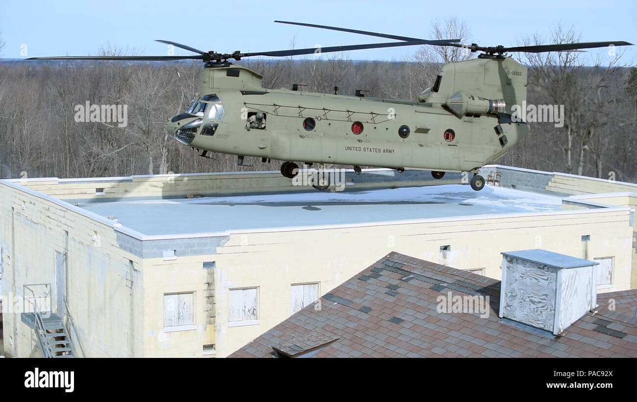 A  CH-47F helicopter  flown by the New York Army National Guard's Company B, 3rd Battalion 126th Aviation, approaches a rooftop LZ at Fort Drum, N.Y.'s urban training site during joint training with the New York Air National Guard's  274th Air Support Operations Squadron (ASOS) on Saturday, March 5, 2016. The 274th mission is to advise U.S. Army commanders on how to best utilize U.S. and NATO assets for Close Air Support. The CH-47 aircrew supported the joint terminal attack controllers of the 274th in an air insertion exercise in an urban environment. (U.S. Air National Guard photo by Master  Stock Photo