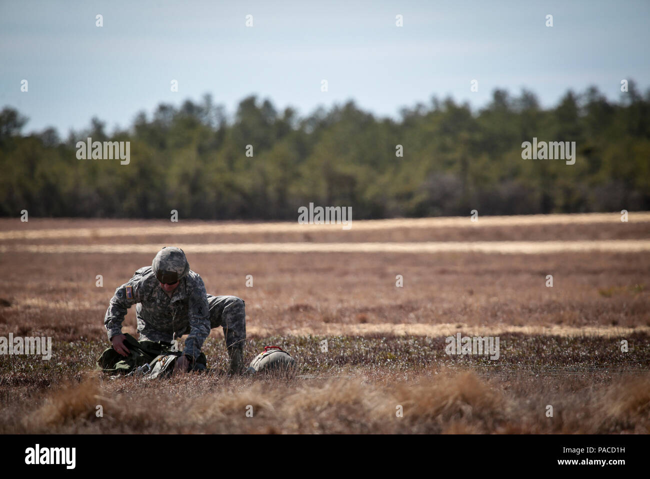 A U.S. Army Reserve paratrooper packs his chute after a helicopterborne parachute jump at Coyle