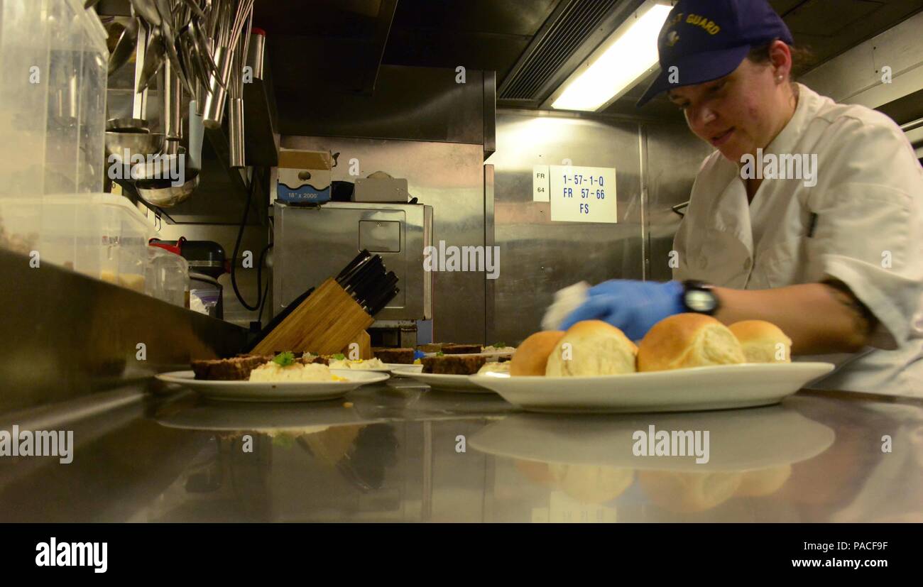 Petty Officer 2nd Class Jenna Gros, a food service specialist aboard USCGC  Kukui (WLB 203), prepares plates for a dinner of enlisted members and  officers in the wardroom, March 12, 2016. Each
