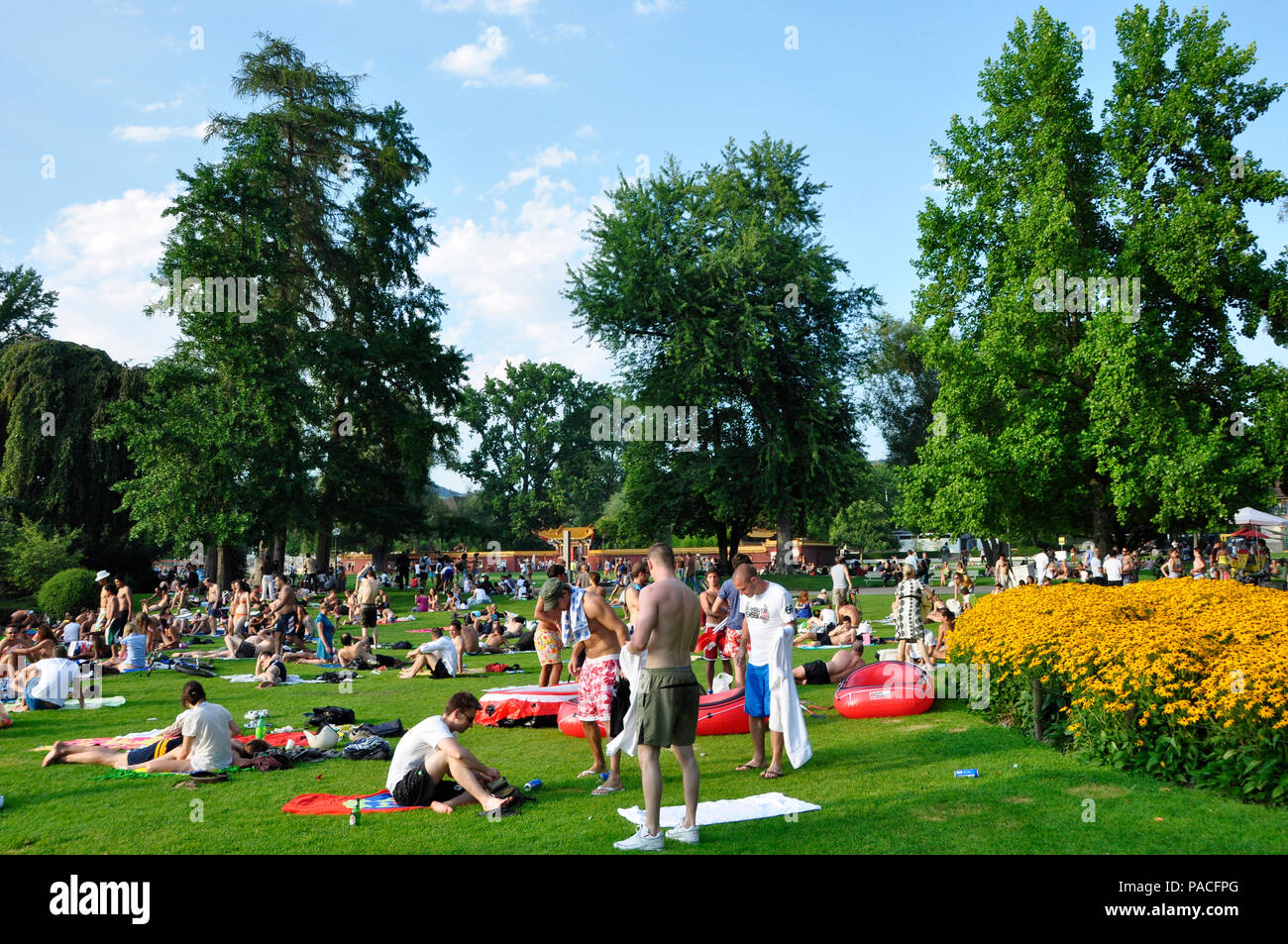 Sumertime at the boarder of lake Zürich: Masses of peoples relaxing, grilling and enjoying the sunshine in the chines garden lake park Stock Photo
