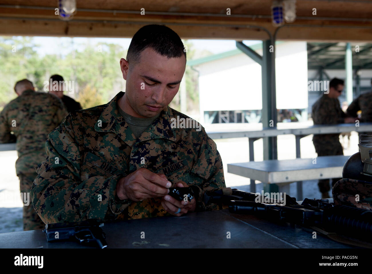 U.S. Marine Staff Sgt. Felix Diaz, a combat instructor with the School of Infantry-East, disassembles his M9 pistol during the Combat Instructor Stakes on Camp Lejeune, N.C., March 16, 2015. The School of Infantry-East hosted the Combat Instructor Stakes, which is a grueling 30-hour competition that pits two man teams against each other, competing in physical, tactical and knowledge based events while carrying a combat load and moving over 50 kilometers on foot. (U.S. Marine Corps photo by Lance Cpl. Jose Villalobosrocha) Stock Photo