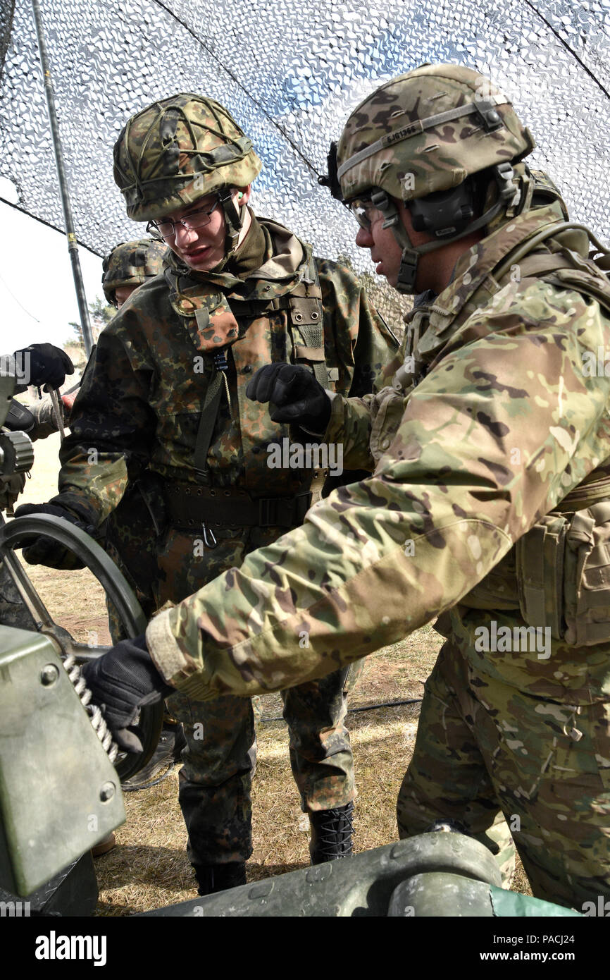 Spc. Julio Guerra (right,) a cannon crewmember assigned to Archer Battery, Field Artillery