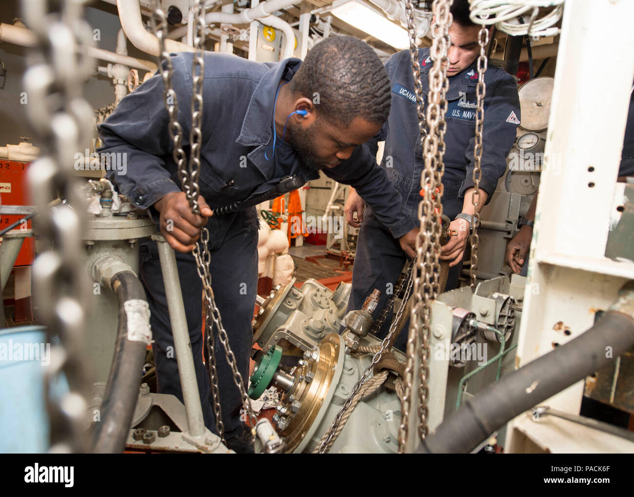 160318-N-DQ503-006 ATLANTIC OCEAN (March 18, 2016) – Gas Turbine Systems Technician 2nd Class Kevin Elliot, from Newark, N.J., hoists a replacement compressor into place in a main engine room aboard the guided-missile destroyer USS Roosevelt (DDG 80). Roosevelt is underway conducting Composite Training Unit Exercise (COMPTUEX) with the Dwight D. Eisenhower Carrier Strike Group in preparation for a future deployment. (U.S. Navy Photo by Mass Communication Specialist 3rd Class Taylor A. Elberg/Released) Stock Photo