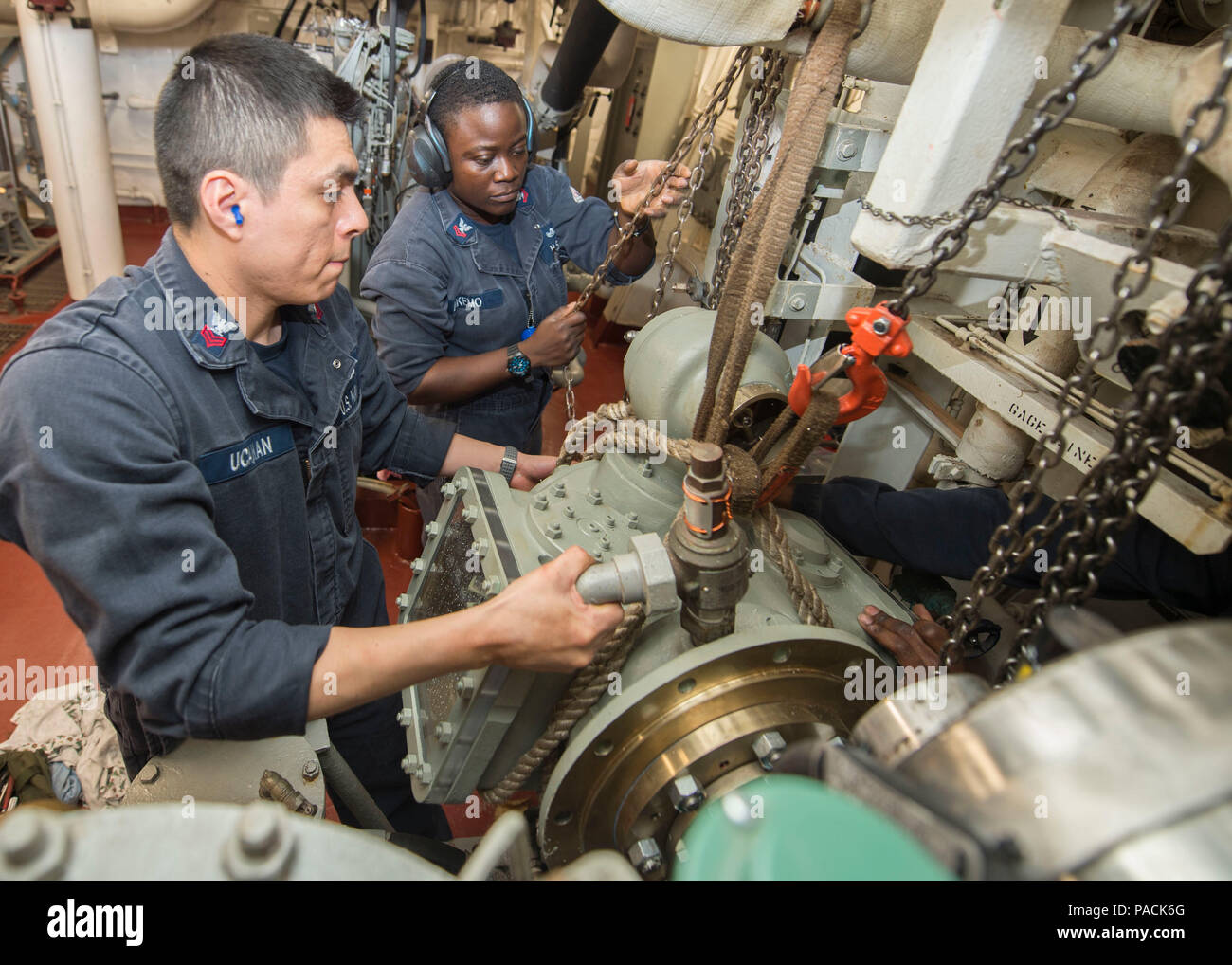 160318-N-DQ503-021 ATLANTIC OCEAN (March 18, 2016) – Gas Turbine Systems Technician 1st Class Rodolfo Ucanan, left, from Lima, Peru and Gas Turbine Systems Technician 2nd Class Cynthia Akemo, from Lagos, Nigeria, installs a replacement a main engine room aboard the guided-missile destroyer USS Roosevelt (DDG 80). Roosevelt is underway conducting Composite Training Unit Exercise (COMPTUEX) with the Dwight D. Eisenhower Carrier Strike Group in preparation for a future deployment. (U.S. Navy Photo by Mass Communication Specialist 3rd Class Taylor A. Elberg/Released) Stock Photo