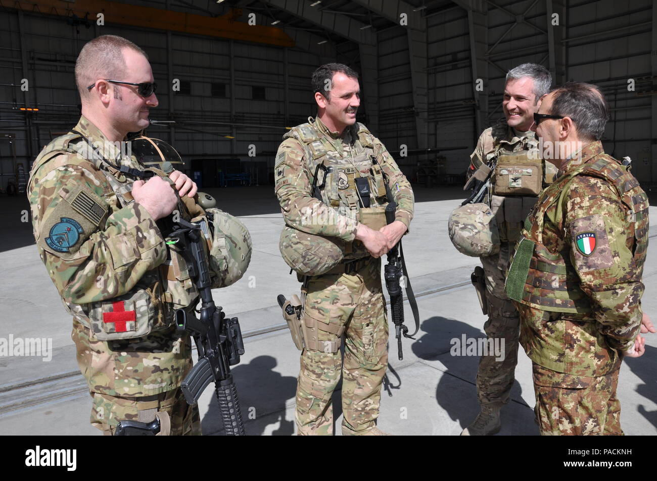 Italian army Gen. Salvatore Farina, commander, NATO JFC-Brunssum (right), talks to two fixed-wing advisers to the Afghan air force about the C-130 Hercules, during a visit to AAF and Train, Advise, Assist Command-Air (TAAC-Air) personnel March 19, 2016, at Hamid Karzai International Airport, Afghanistan. He wanted to learn about the air force missions and reaffirm support to NATO’s international partners. (U.S. Air Force photos by Capt. Eydie Sakura/released) Stock Photo