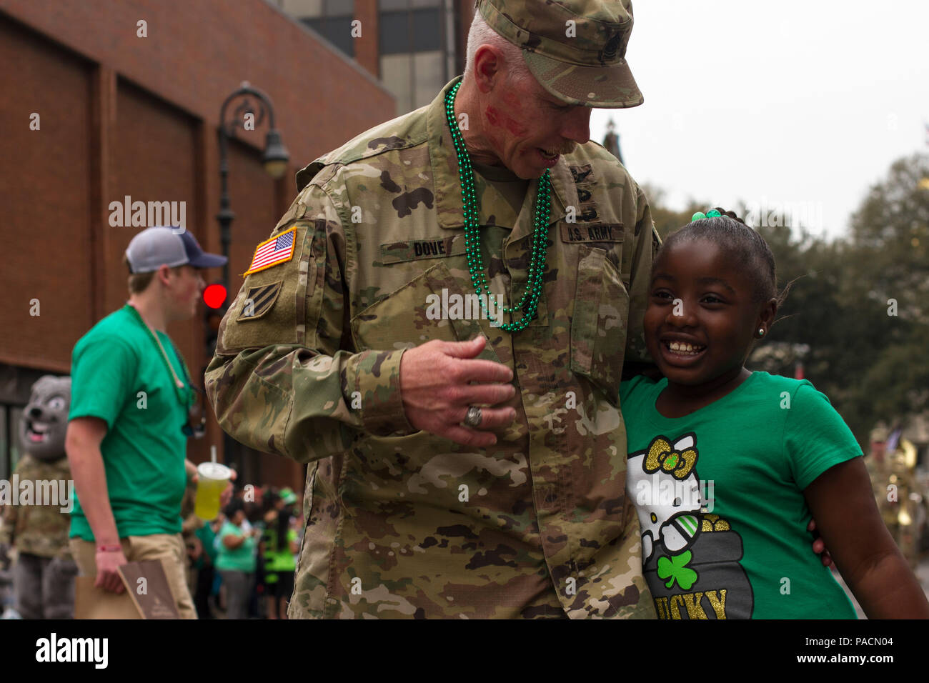 The command sergeant major of 3rd Combat Aviation Brigade, Command Sgt. Maj. George Dove, gives a hug to a spectator during the 192nd St. Patrick’s Day Parade March 17 in downtown Savannah. (Photo by Sgt. William Begley, 3rd CAB Public Affairs) Stock Photo