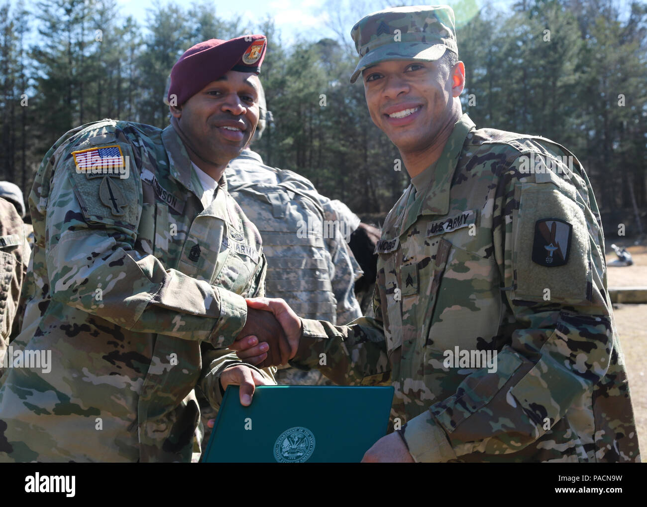 U.S. Army 1st. Sgt. Endesha Johnson, assigned to 55th Signal Company (Combat Camera), congratulates Sgt. Samuel Nobles following his promotion at Fort George G. Meade, Md., March 2, 2016. The promotion from Specialist to Sergeant marks the responsibility instilled into the new noncommissioned officer. (U.S. Army photo by Spc. Alyssa Madero/Released) Stock Photo