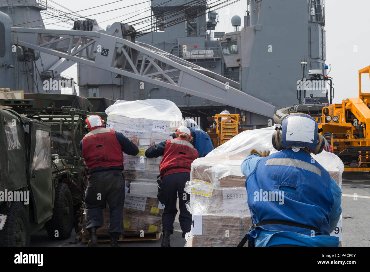 160316-N-RM689-124 EAST SEA (March 16, 2016) - Sailors assigned to amphibious dock landing ship USS Ashland (LSD 48) push pallets towards the boat deck where the working party waits to unload them during a vertical replenishment (VERTREP) at sea. Ashland is assigned to the Bonhomme Richard Expeditionary Strike Group and is participating in Ssang Yong 16, a biennial combined amphibious exercise conducted by forward-deployed U.S. forces with the Republic of Korea navy and Marine Corps, Australian army and Royal New Zealand army forces in order to strengthen our interoperability and working relat Stock Photo