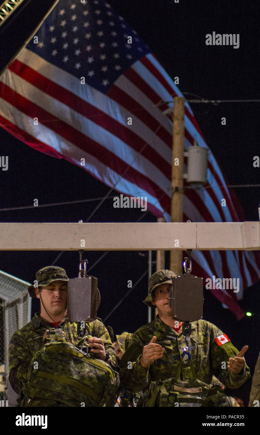 Two Canadian soldiers weigh their ruck sacks in the early morning hours
