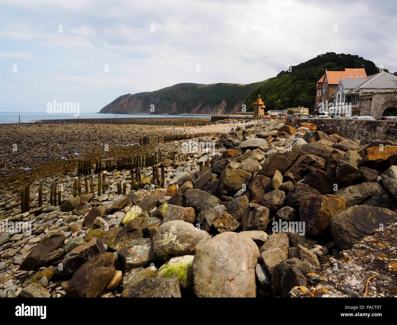 Boulder strewn foreshore exposed at low tide at Lynmouth, Devon, Uk.  Foreland point in the dustance. Stock Photo