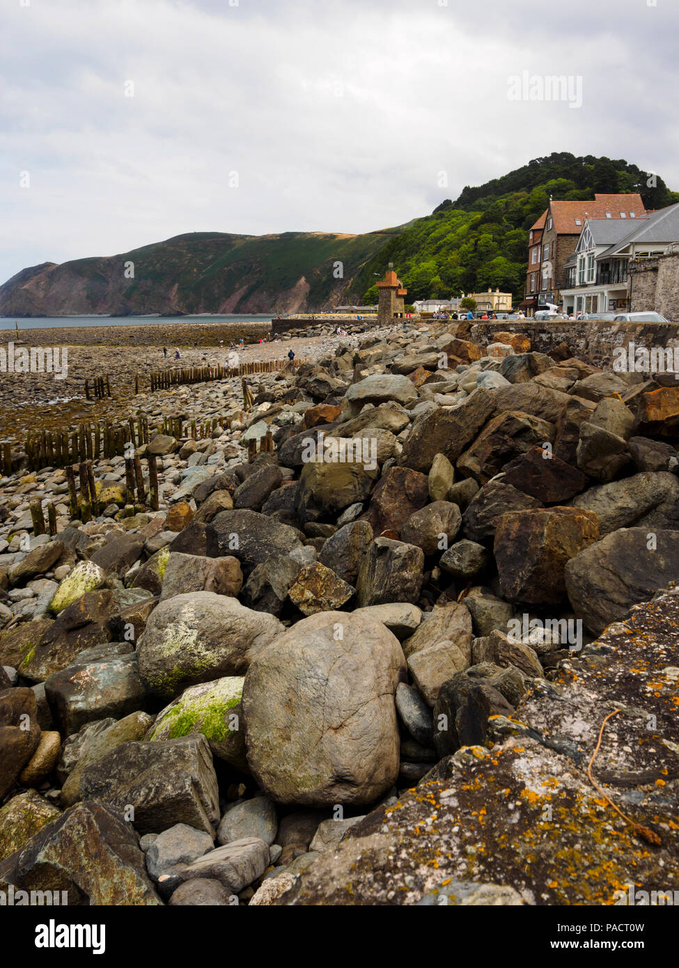 Boulder strewn foreshore exposed at low tide at Lynmouth, Devon, Uk.  Foreland point in the dustance. Stock Photo