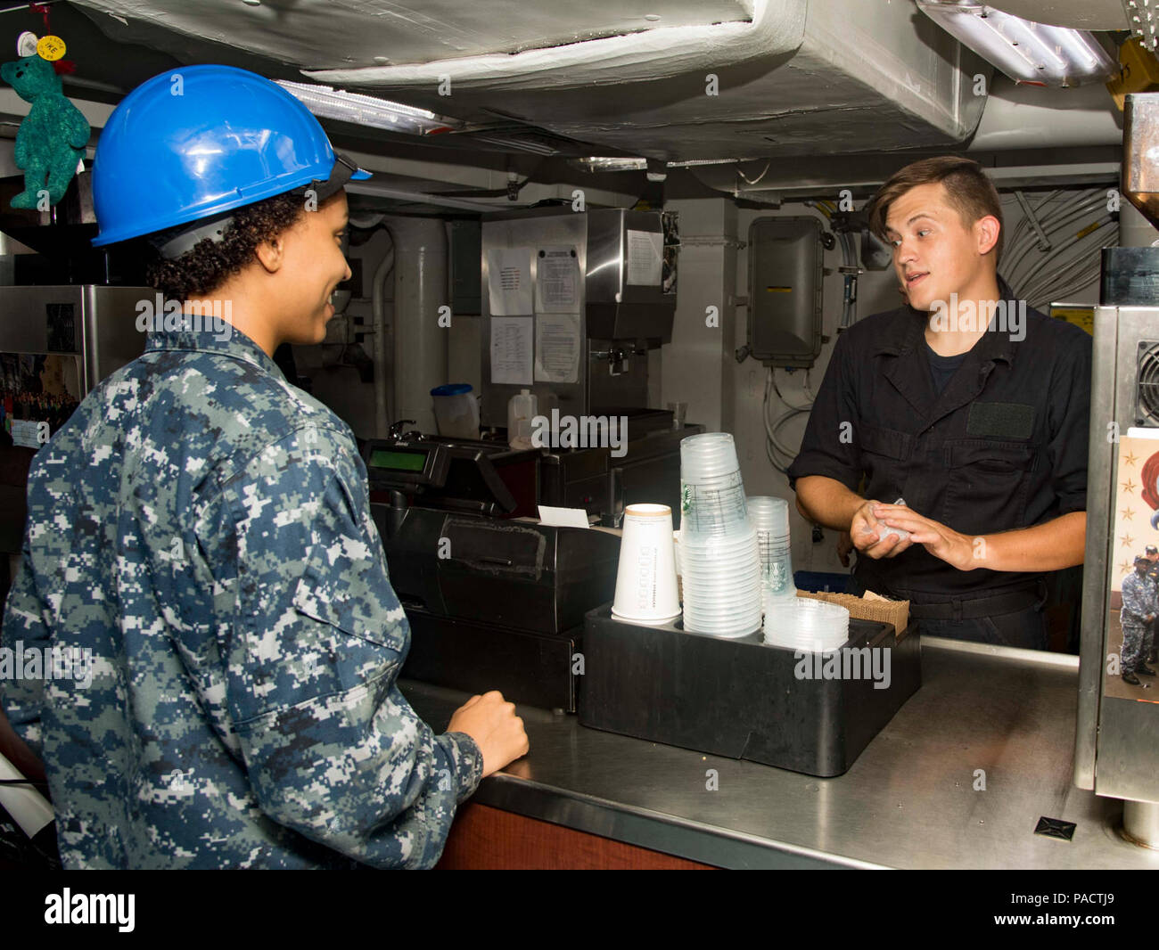 PORTSMOUTH, Va. (Aug. 23, 2017) Aviation Boatswain’s Mate (Handling) Airman Jasmine Miller, from Irmo, S.C., left, orders coffee from Airman Steven Swain, from Warner Robins, Ga., right, at the ship's coffee shop aboard the aircraft carrier USS Dwight D. Eisenhower (CVN 69)(Ike). Ike is preparing for a Planned Incremental Availability (PIA) at Norfolk Naval Shipyard during the maintenance phase of the Optimized Fleet Response Plan (OFRP) Stock Photo