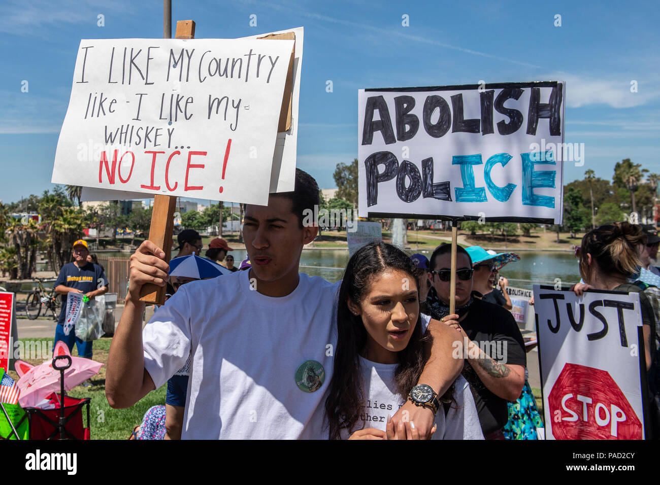 Los Angeles, USA. 21 July 2018.  FTwo young people hold 'abolish pol-ice' sign at McArthur Park during Families Belong Together March and ICE (Immigration and Customs Enforcement protest in Los Angeles, California on July 21, 2018. Despite the ending of family separations at US borders many children that were taken away from their parents are still not re-united with their families. Credit: Aydin Palabiyikoglu Credit: Aydin Palabiyikoglu/Alamy Live News Stock Photo