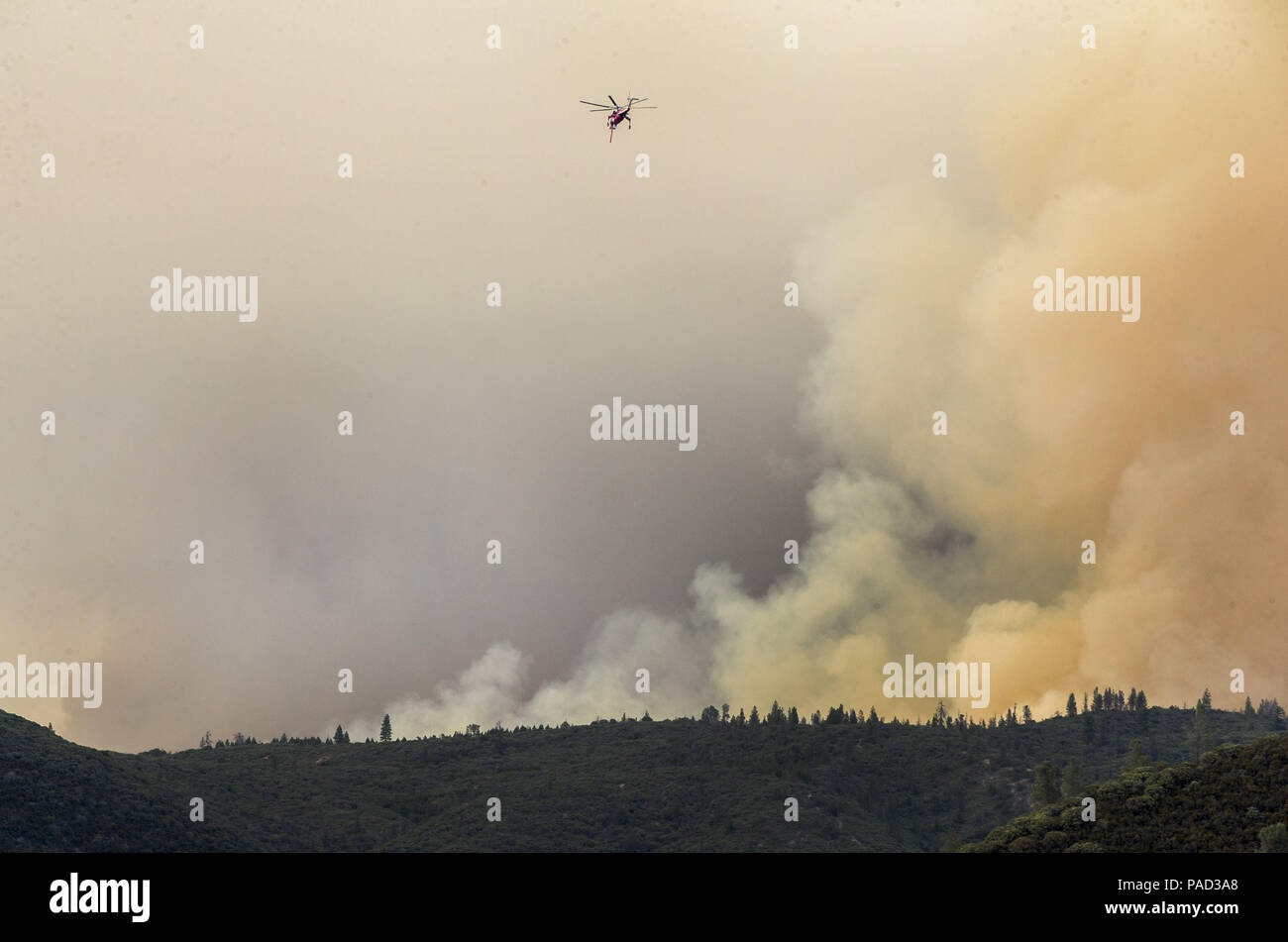 Mariposa, California, U.S.A. 21st July, 2018. A Helicopter looks dwarfed next to the raging smoke. The Ferguson Fire in Mariposa County just west of Yosemite National Park has burned over 29,000 acres and is 6% contained as of Saturday July 21, 2018 according to U.S. Forest Service. Credit: Marty Bicek/ZUMA Wire/Alamy Live News Stock Photo