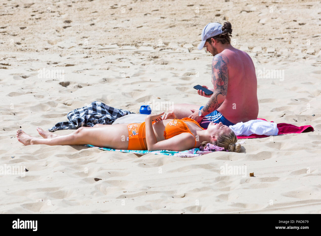 Bournemouth, Dorset, UK. 22nd July 2018. UK weather: hot and sunny at Bournemouth beaches, as sunseekers head to the seaside to soak up the sun. Couple sunbathing on the beach. Credit: Carolyn Jenkins/Alamy Live News Stock Photo
