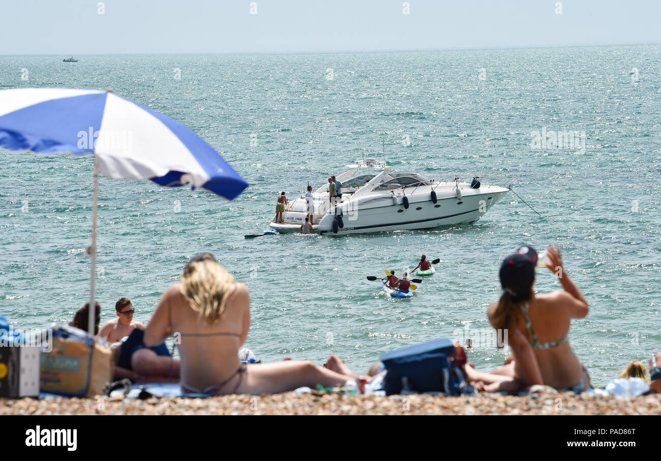 Brighton UK 22nd July 2018 - Brighton beach is packed both on and off shore in hot sunshine as the heatwave weather continues throughout parts of Britain Credit: Simon Dack/Alamy Live News Stock Photo